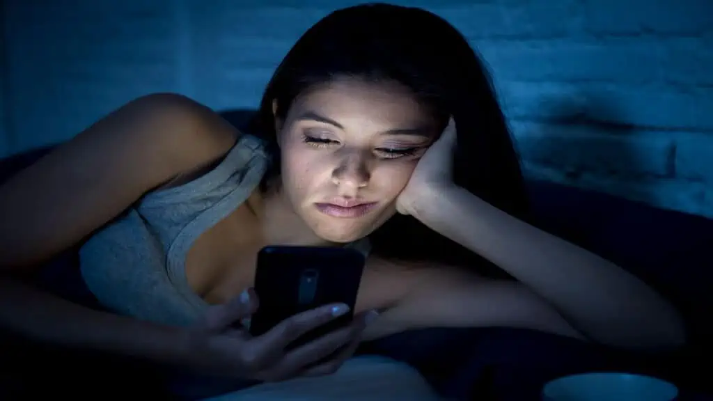 woman on cell phone in bed