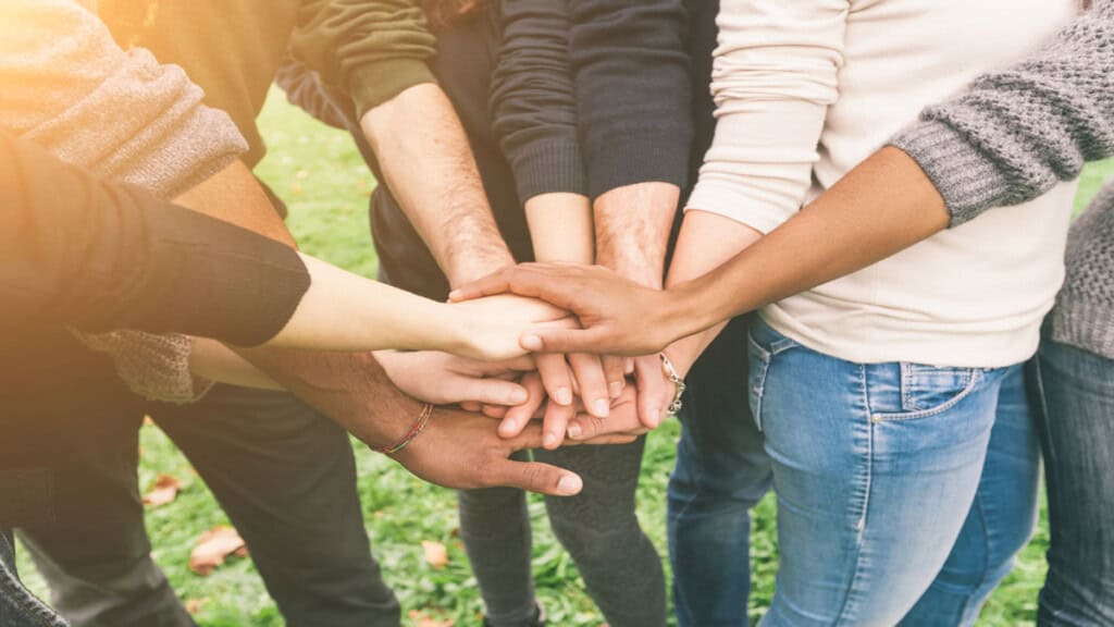 group of friends touching hands