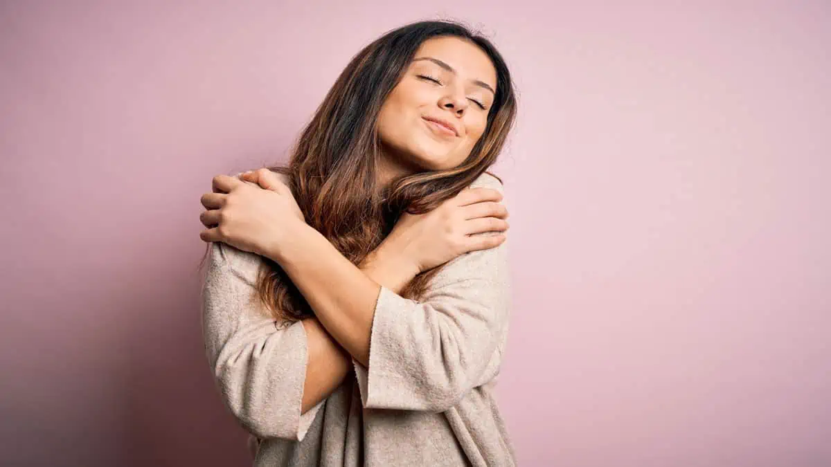 young woman hugging herself